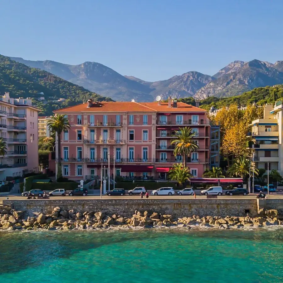 Seafront hotel at the foot of the mountains, seen from a drone